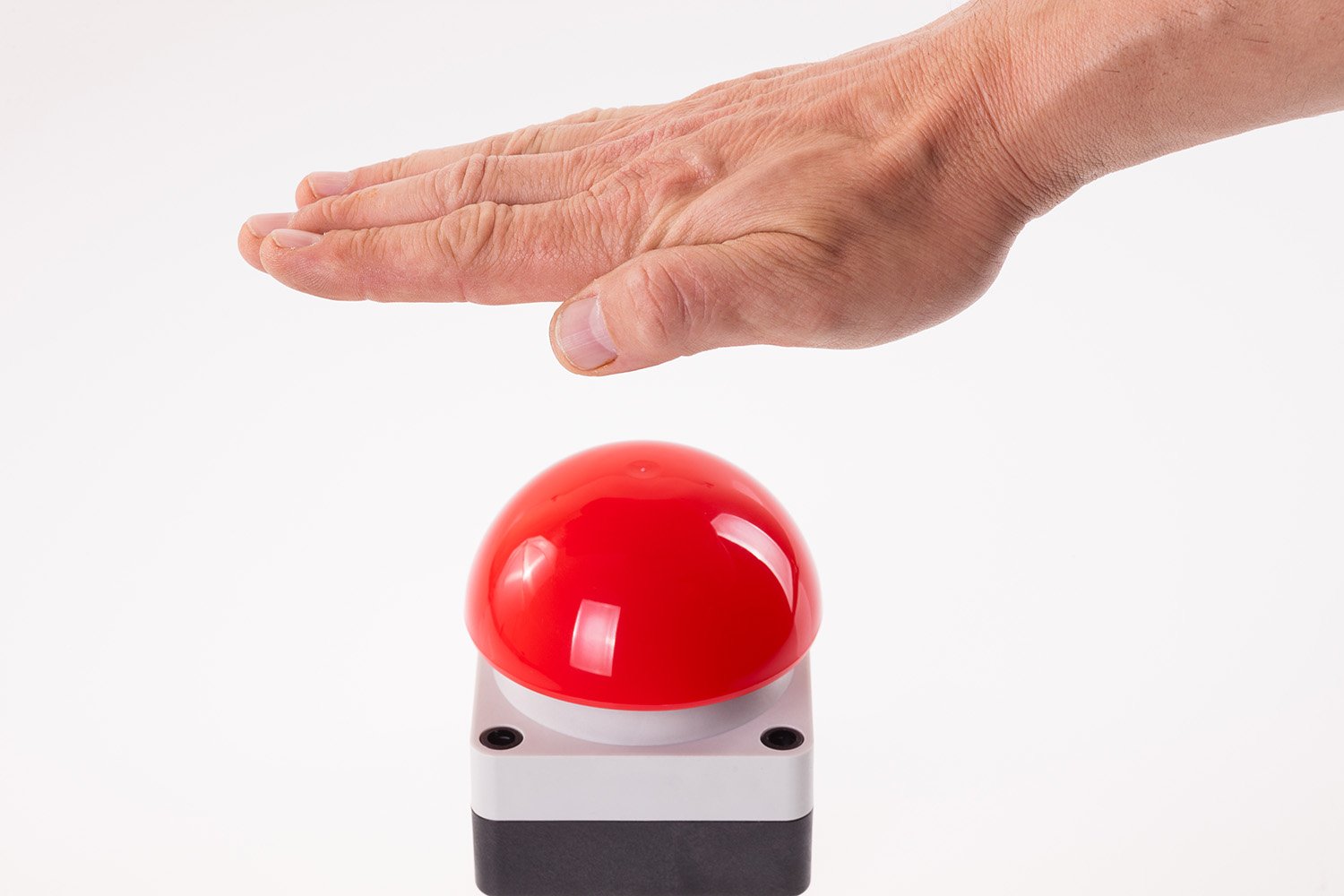 A man's hand presses a big red button. Red button on a dark background. The  threat